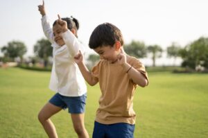 原っぱを笑顔で走る子供たち