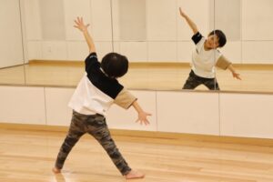 鏡の前でダンスの練習をする幼児