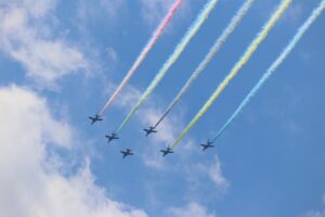 オリンピックカラーの飛行機雲を出すブルーインパルス