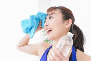 汗を流し水分補給をする女性