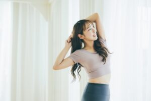 窓辺でストレッチをする女性